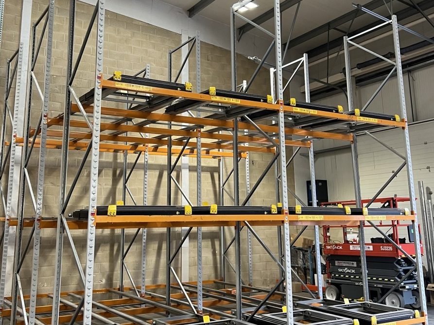 Fully installed push-back racking system with four bays and three beam levels, ready for warehouse storage use.