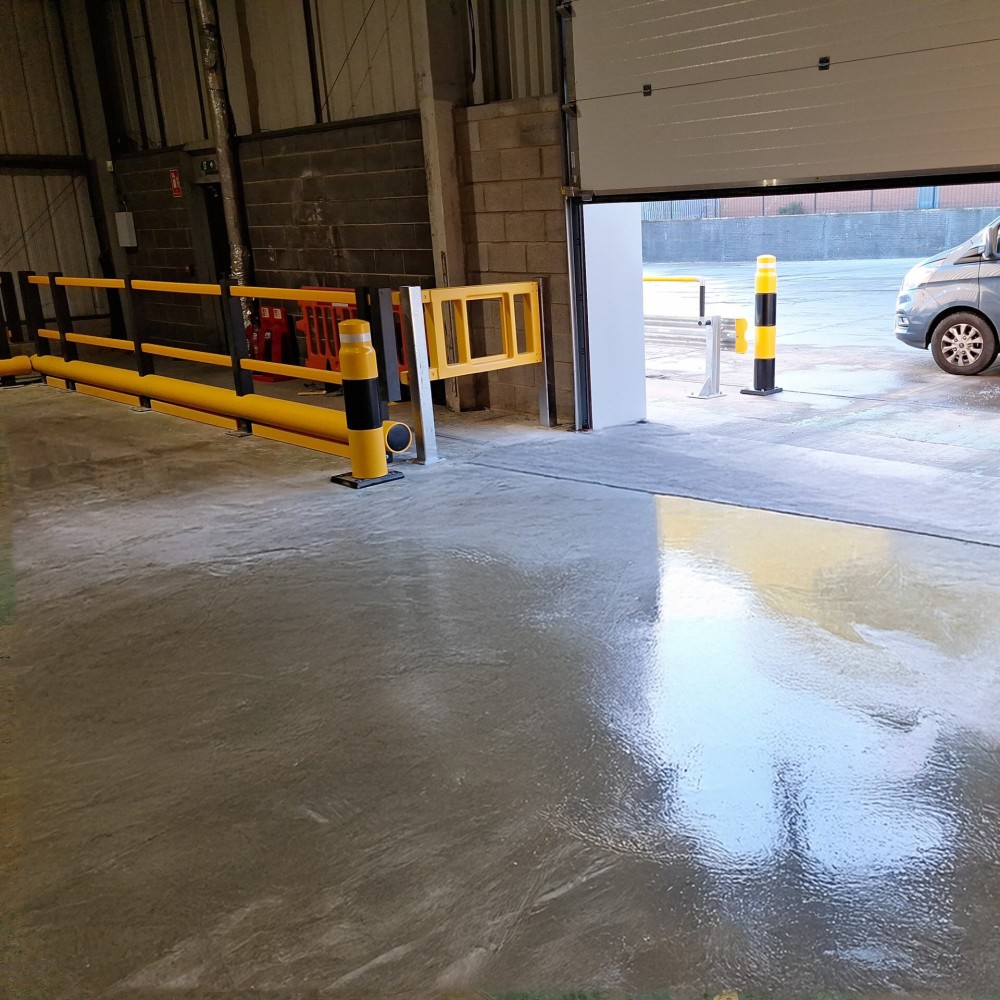 Warehouse safety installation featuring polymer safety barriers with integrated safety gates, ImpactSAFE Bollards protecting the loading bay door and walkway, and a floor rail bumper preventing forklift and MHE intrusion beneath the barriers.